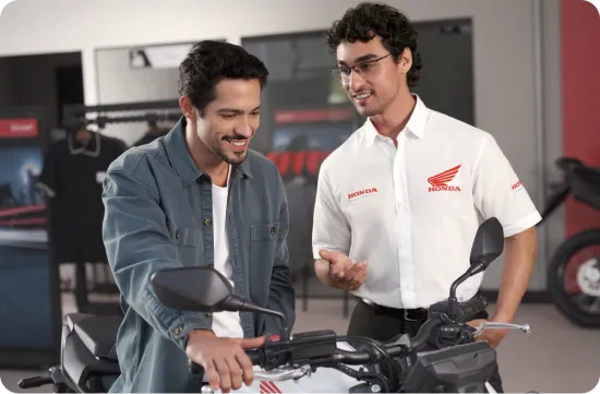 Homem e vendedor olhando a moto honda